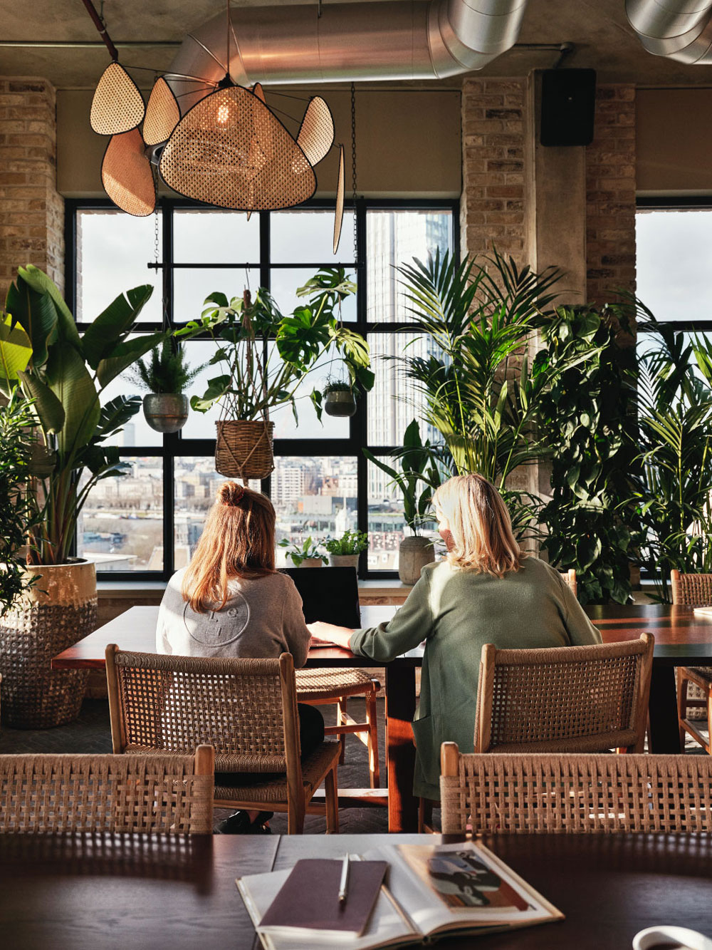 Two girls sit at a desk facing away from the camera
