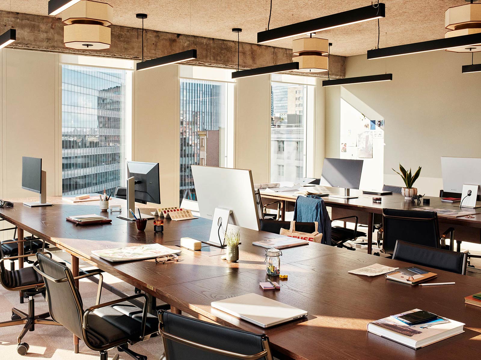 Interior of a sunlit private studio with monitors, desks and chairs