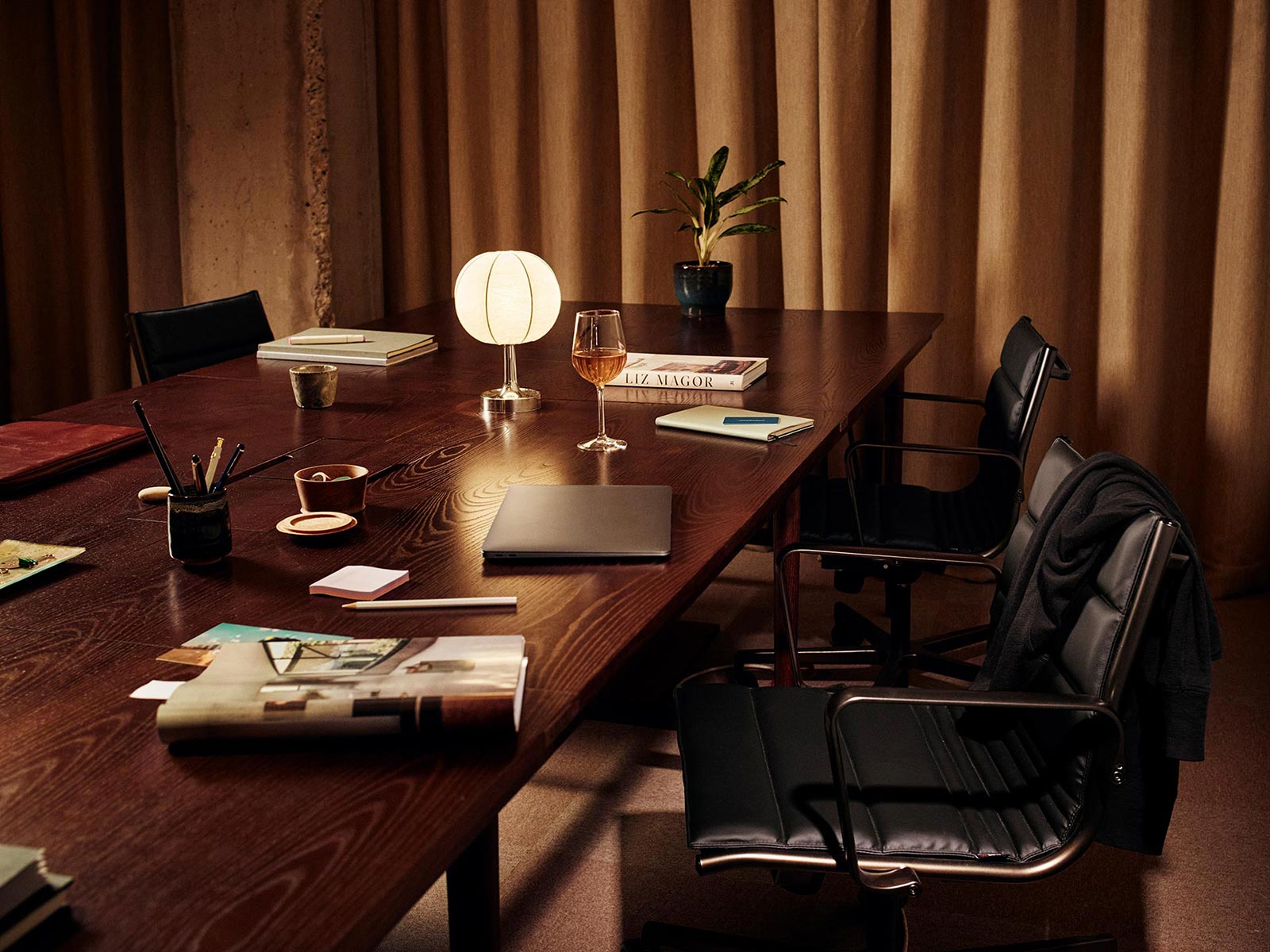 Private studio at night with a laptop next to a glass of something fizzy for late night work.