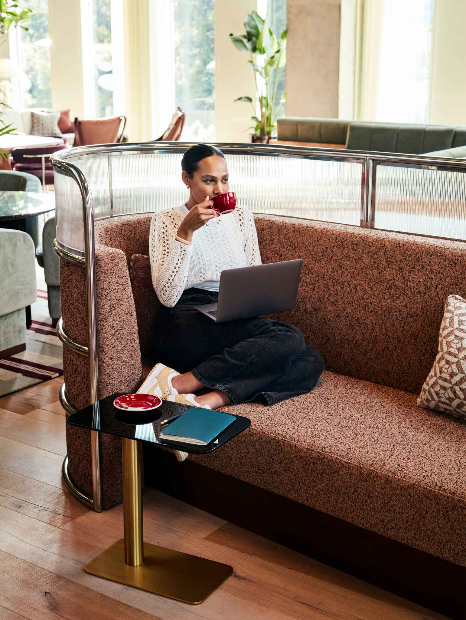 Woman sitting on a sofa having a coffee in Working From_ Brussels