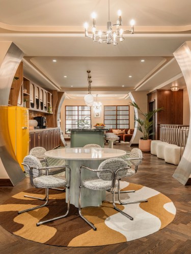 View of the apartment entrance, with a round table and chairs.