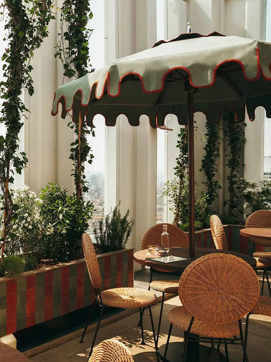 View of the Tope restaurant rooftop, with tables and chairs covered with parasol.